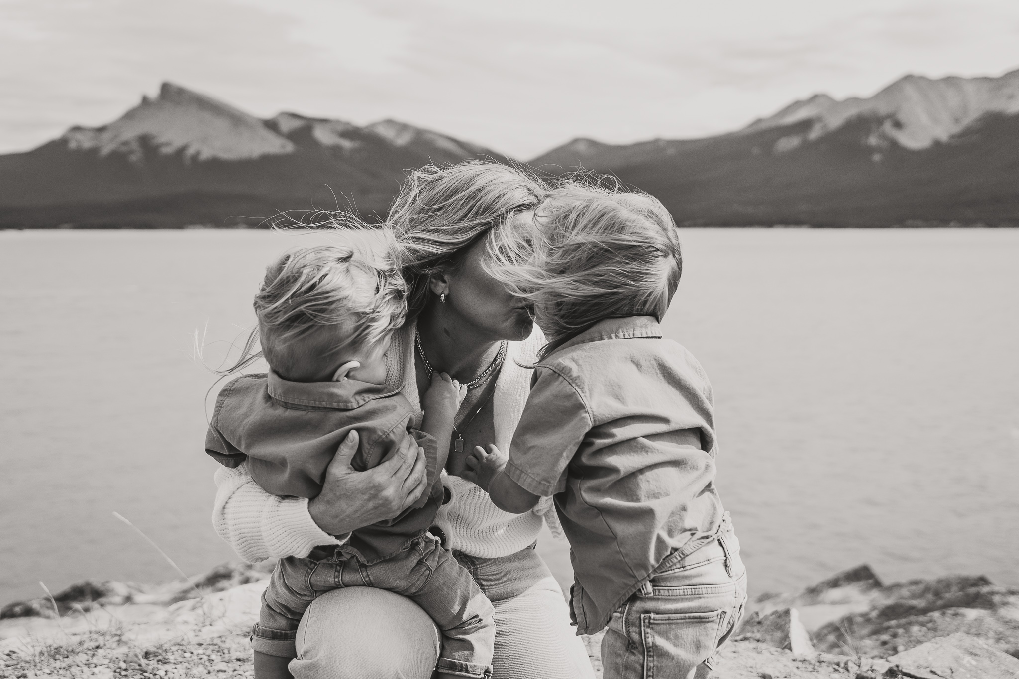 woman with two small children near a lake