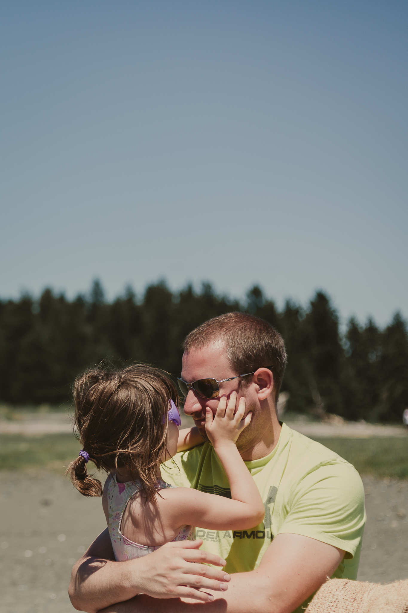 small child holding mans face