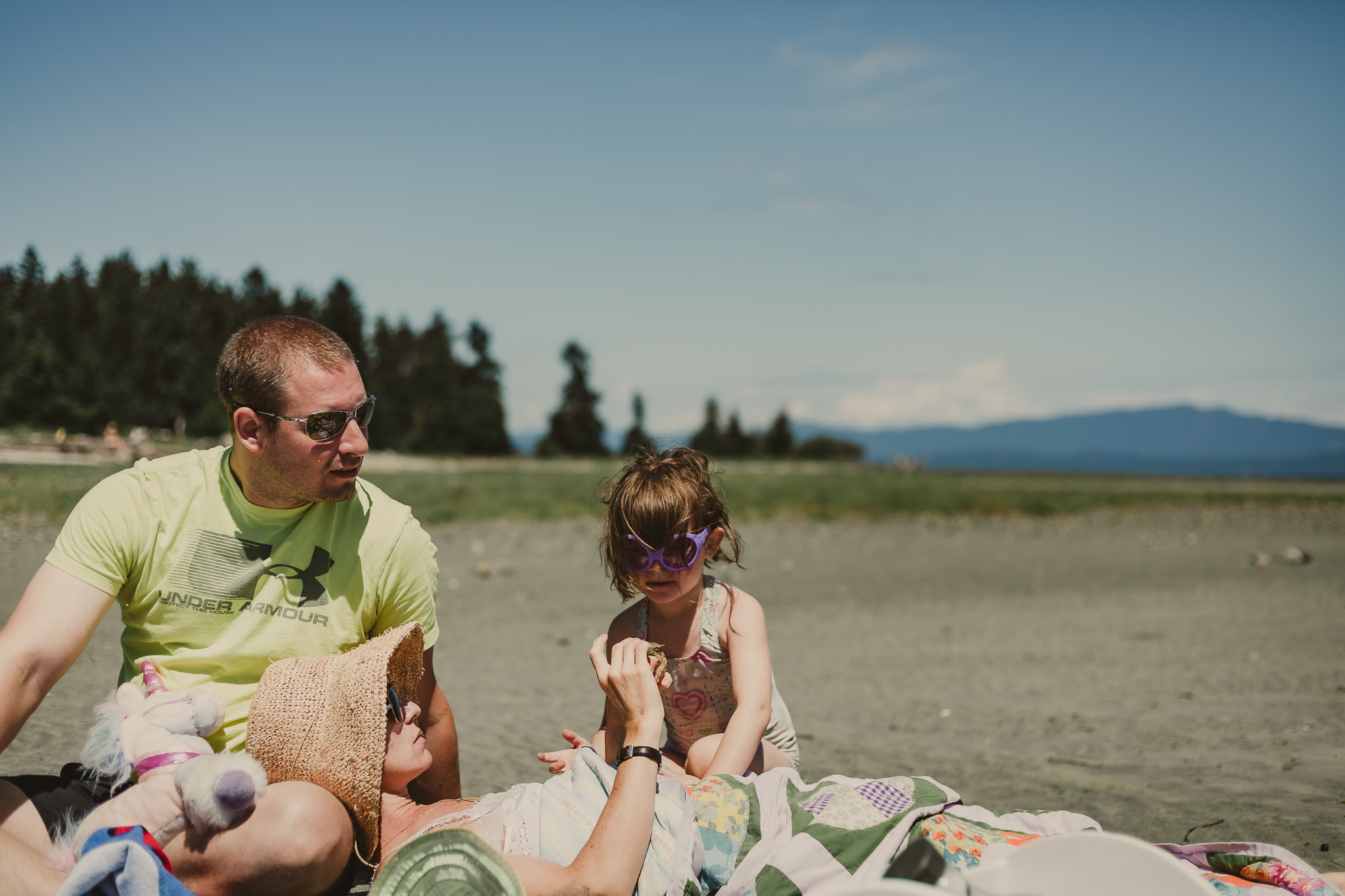 man and woman on beach with small child