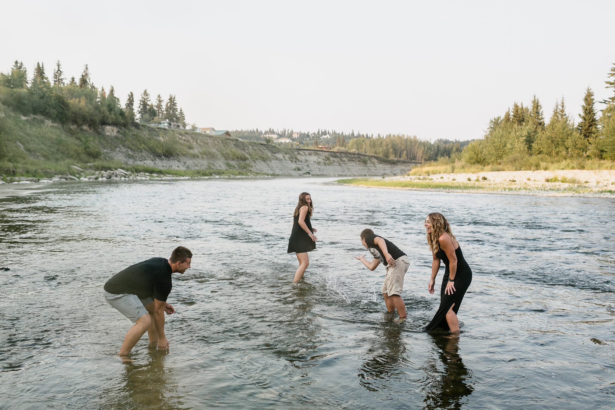 two men and 2 women splashing in the river