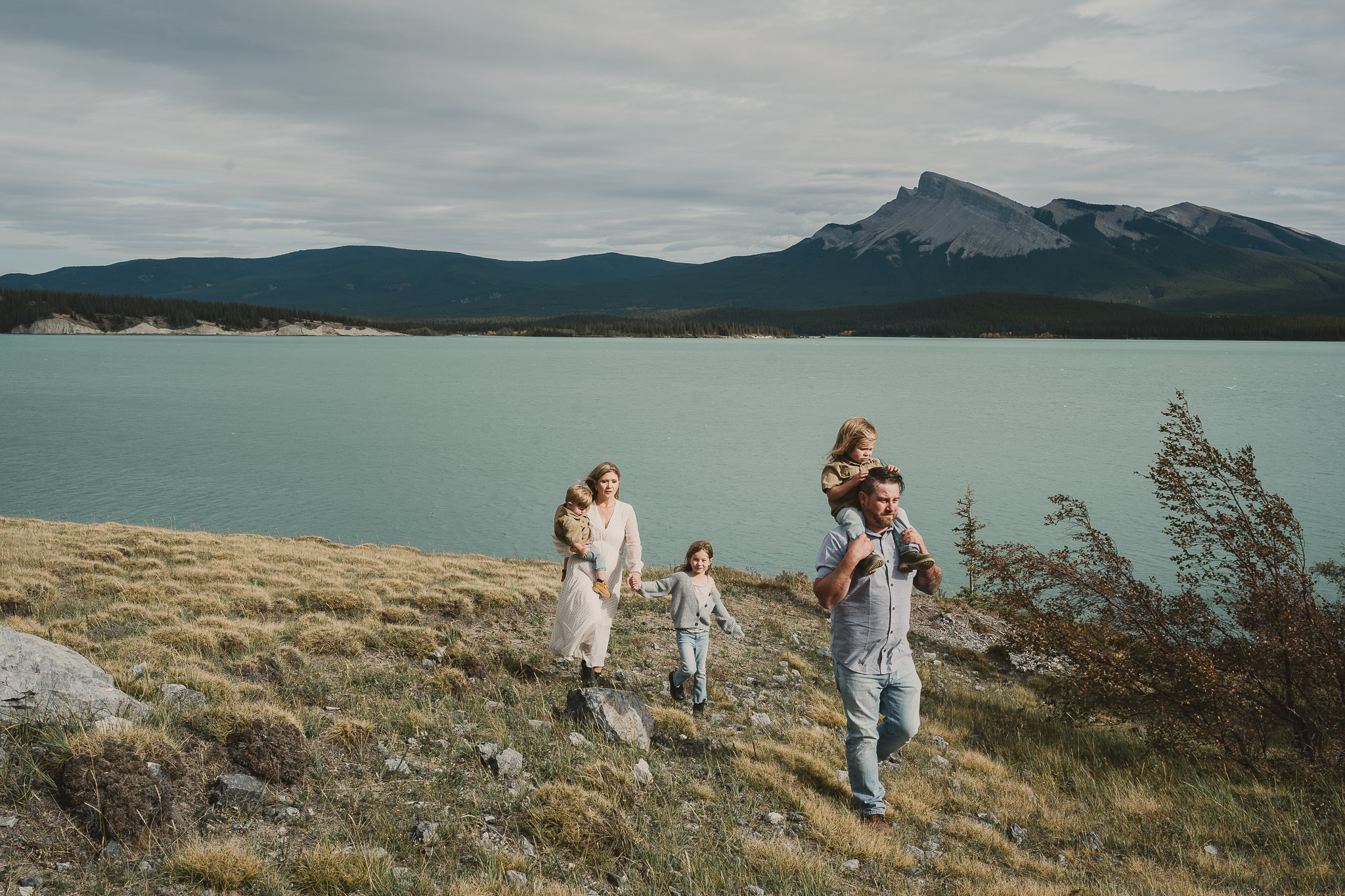 man with small child on shoulders woman holding a small child on hip and a small girls hand in mountains