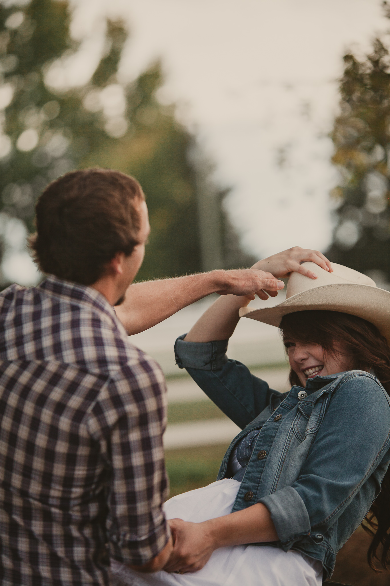 man putting cowboy hat on woman