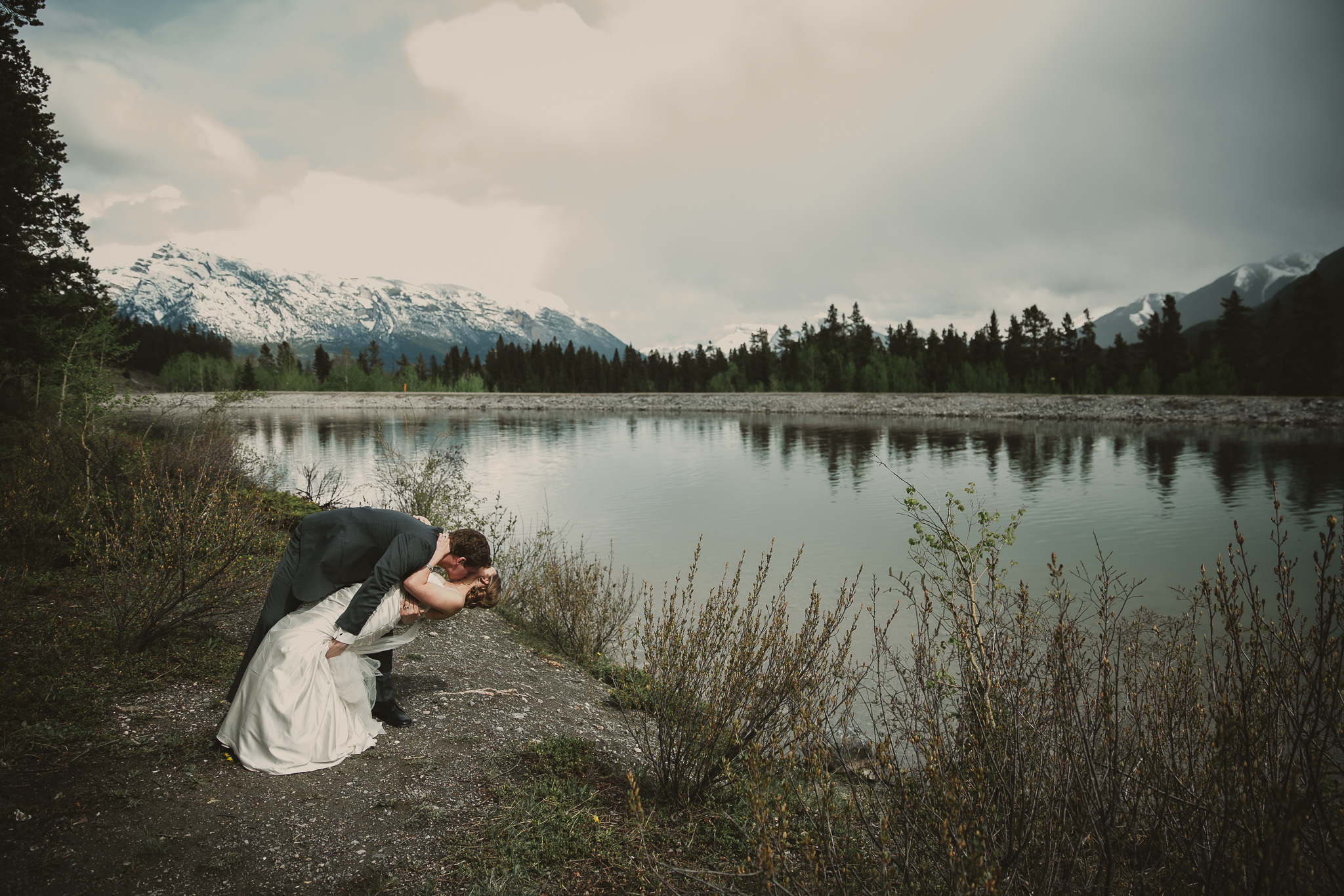 wedding couple dipping and kissing in the mountains