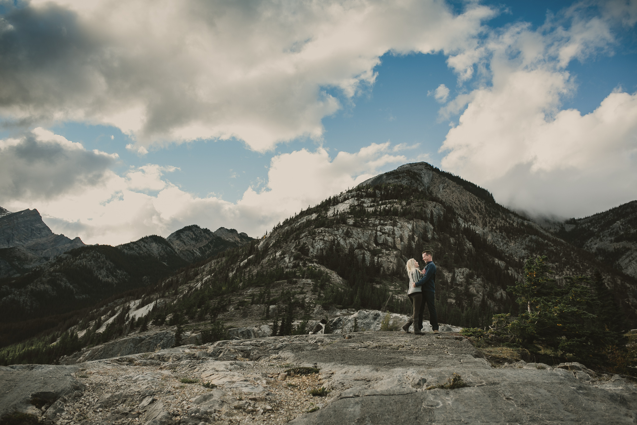 man and woman kissing in the mountains