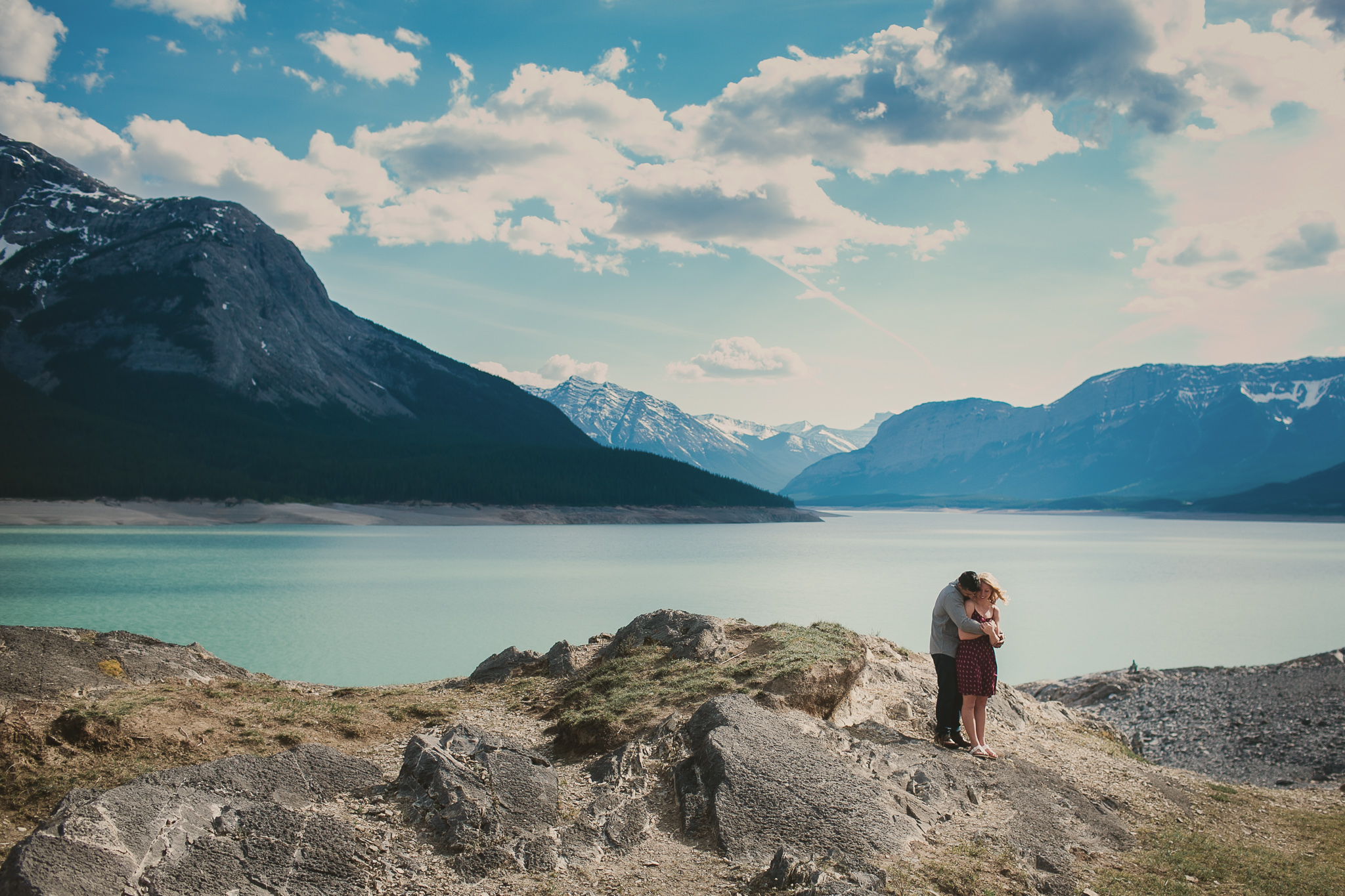 couple embracing by a lake in the mountains