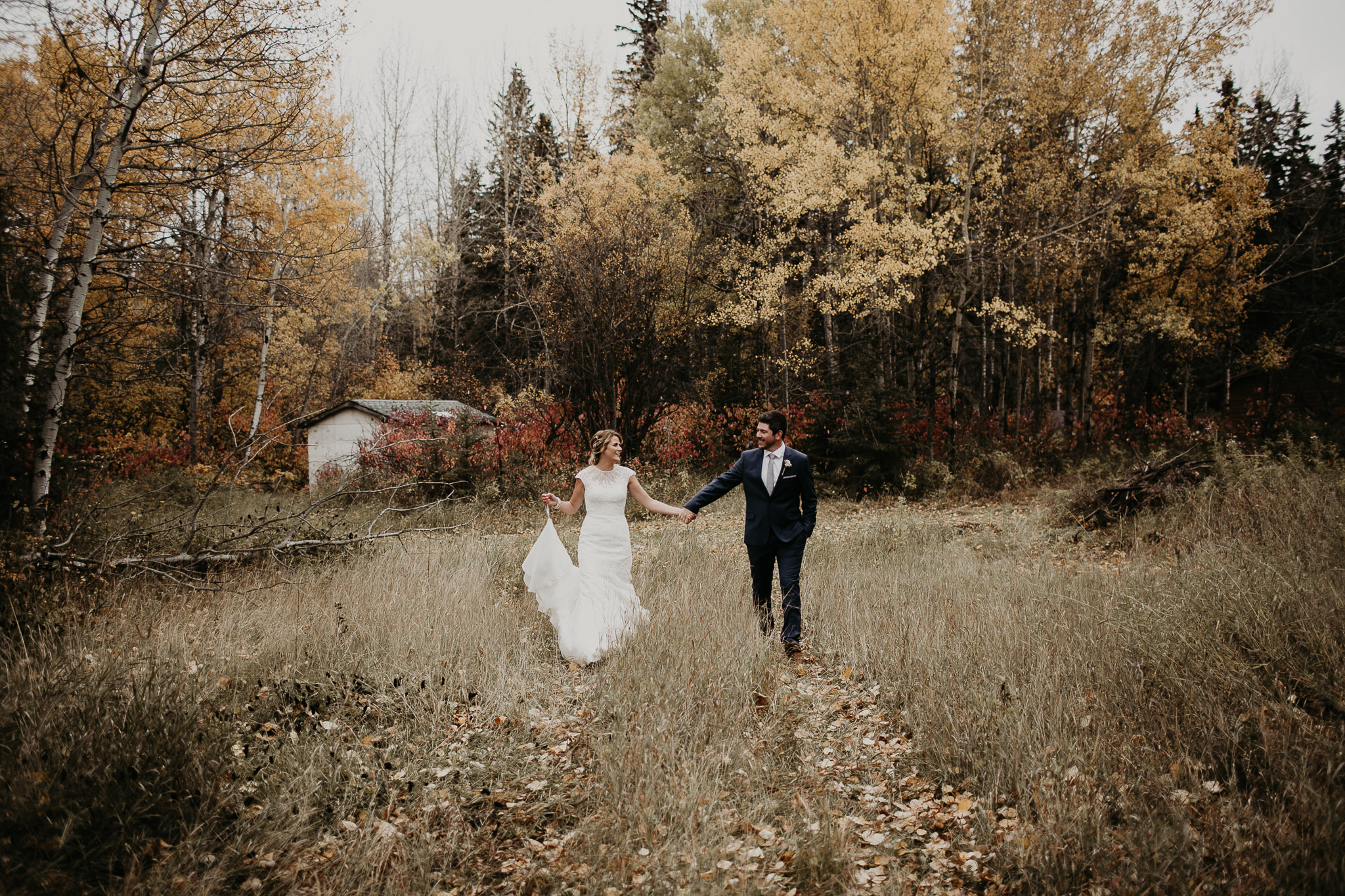 bride and groom holding hands in the forest