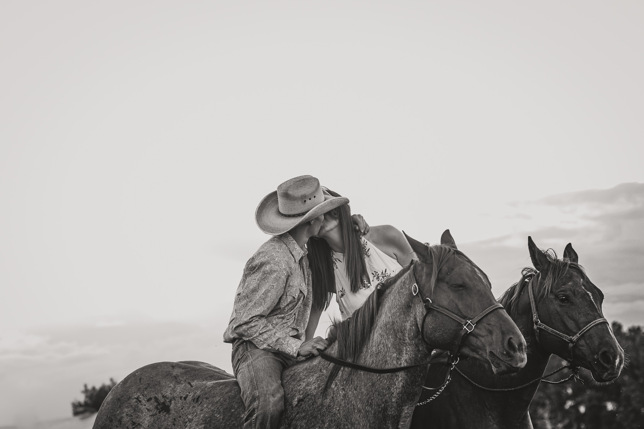 couple on horses kiss black and white