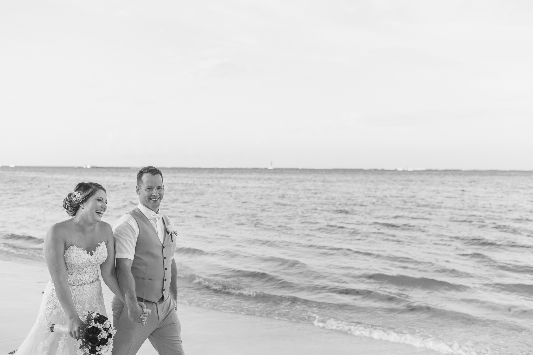 Wedding couple walking holding hands on beach