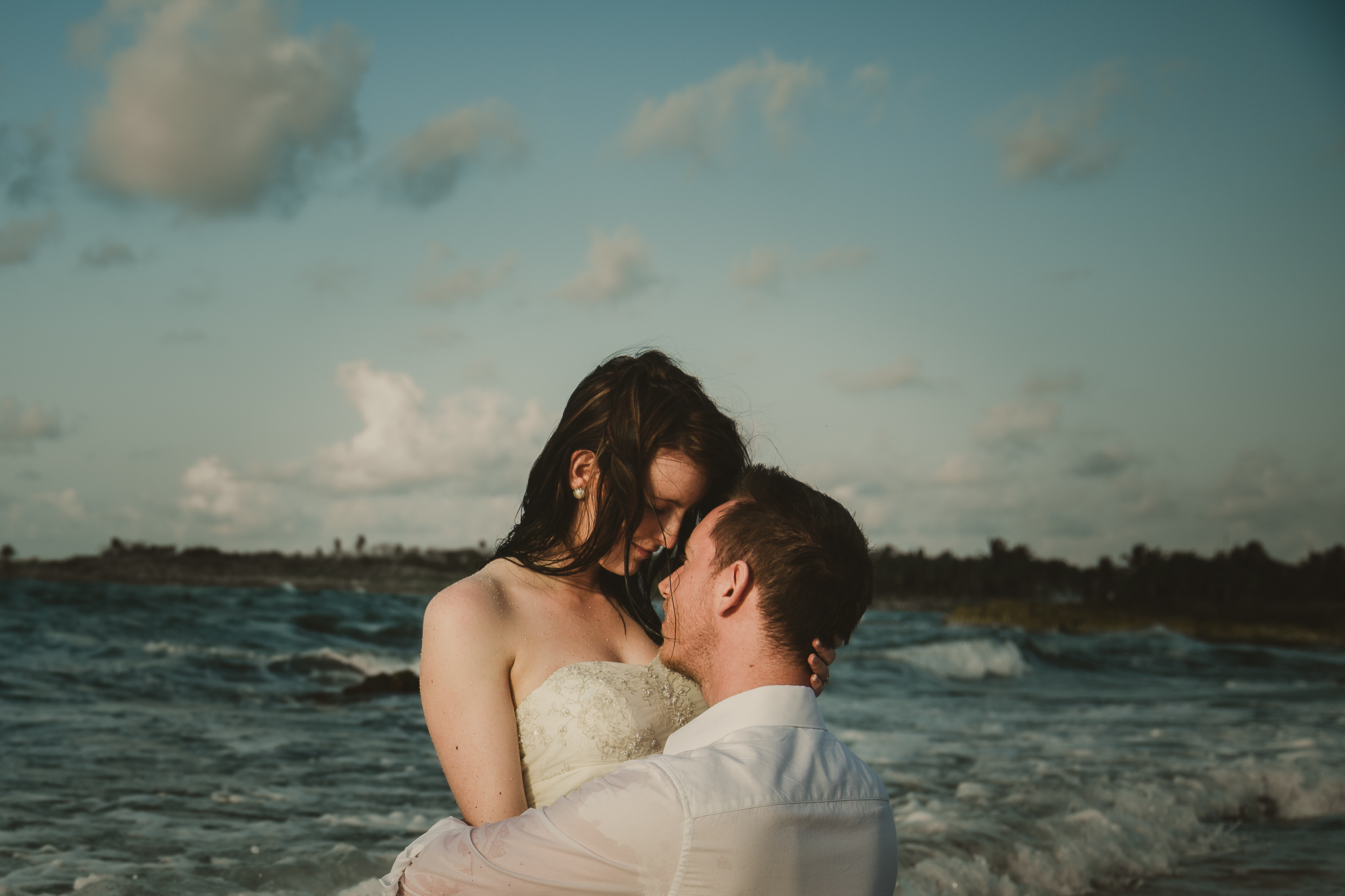 wedding couple embracing in the ocean
