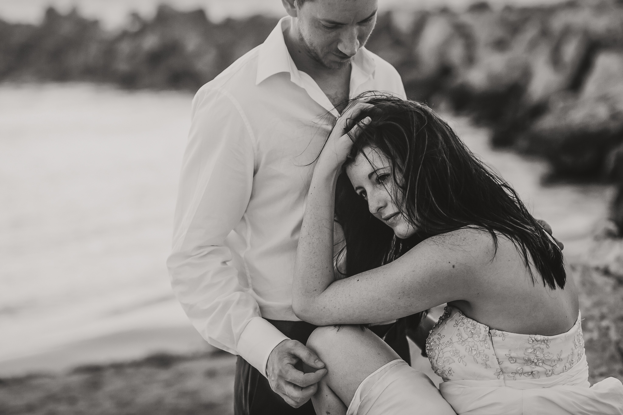 brade and groom sitting by the ocean