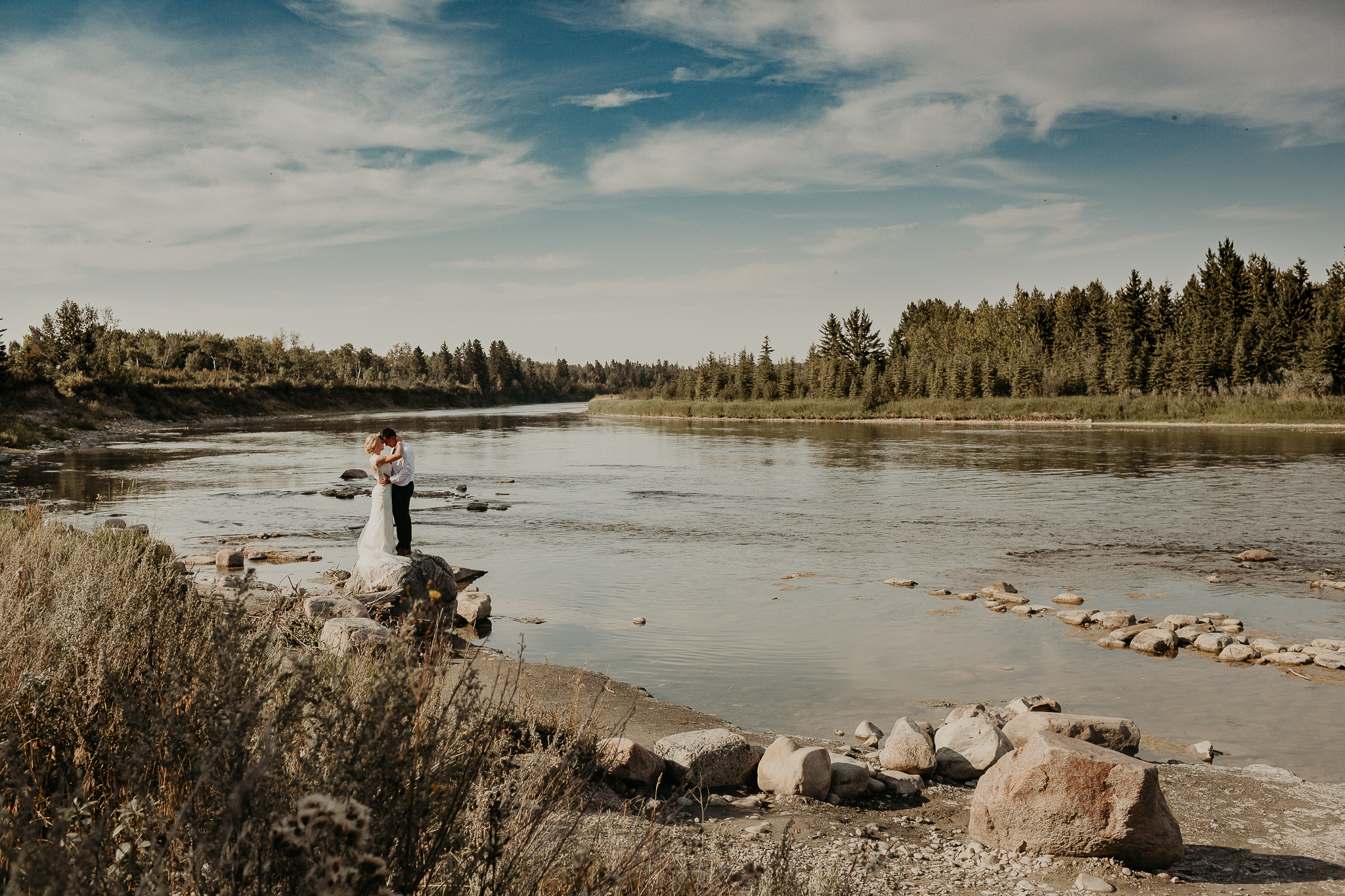 wedding couple standing on a rock in the river