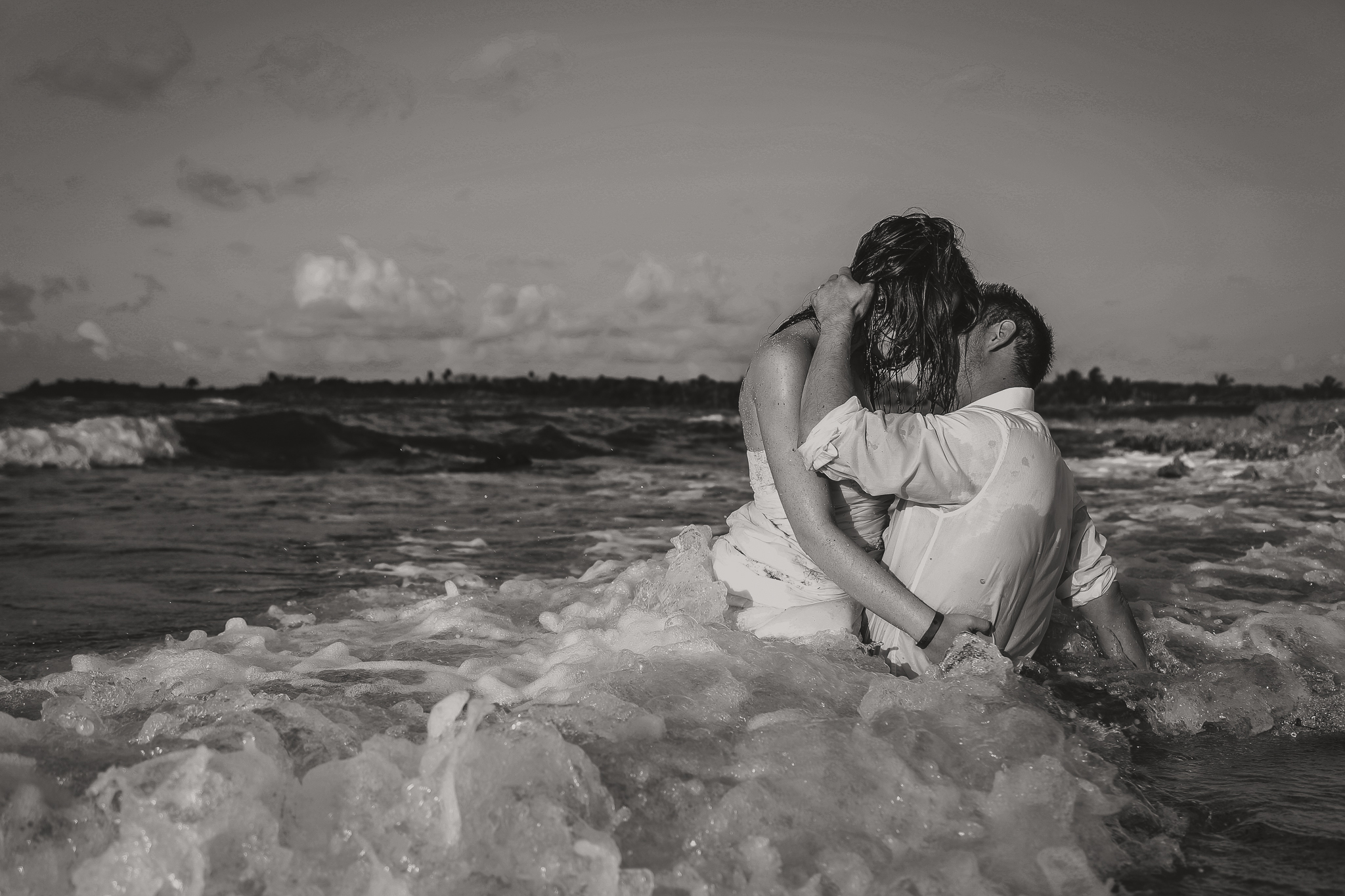 wedding couple kissing in the ocean waves