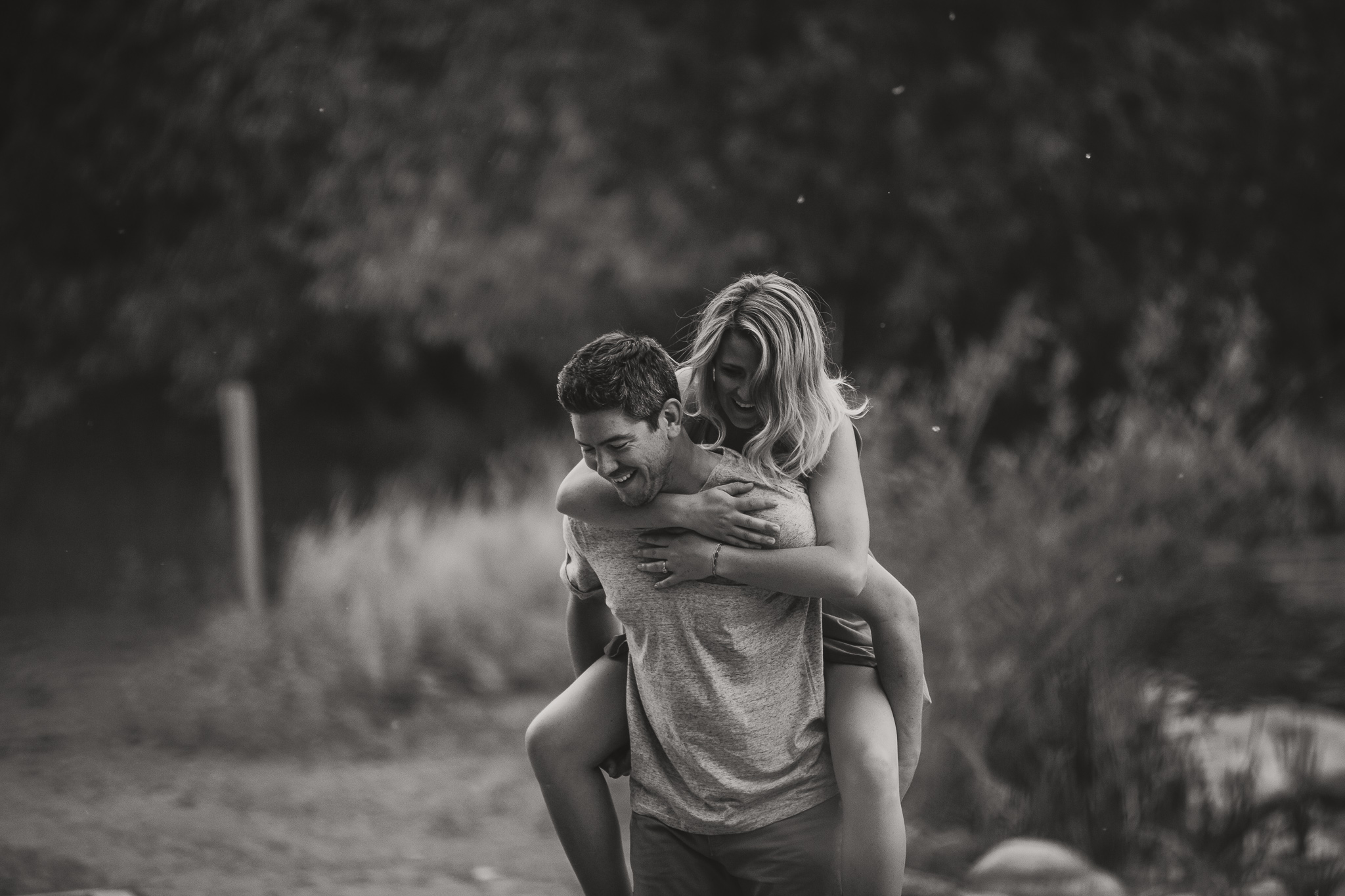 man piggybacks woman black and white