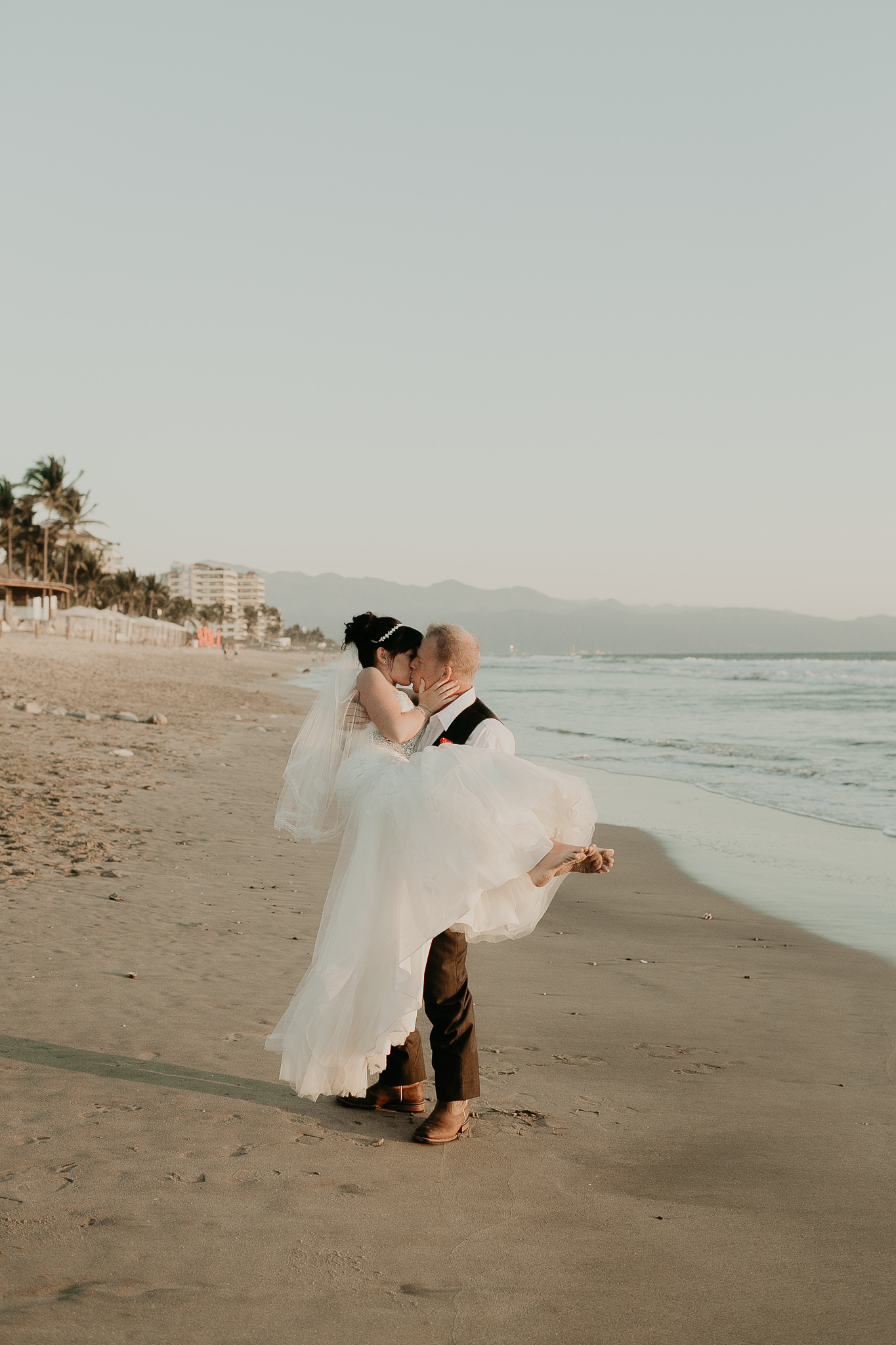 man carrying woman in a wedding dress