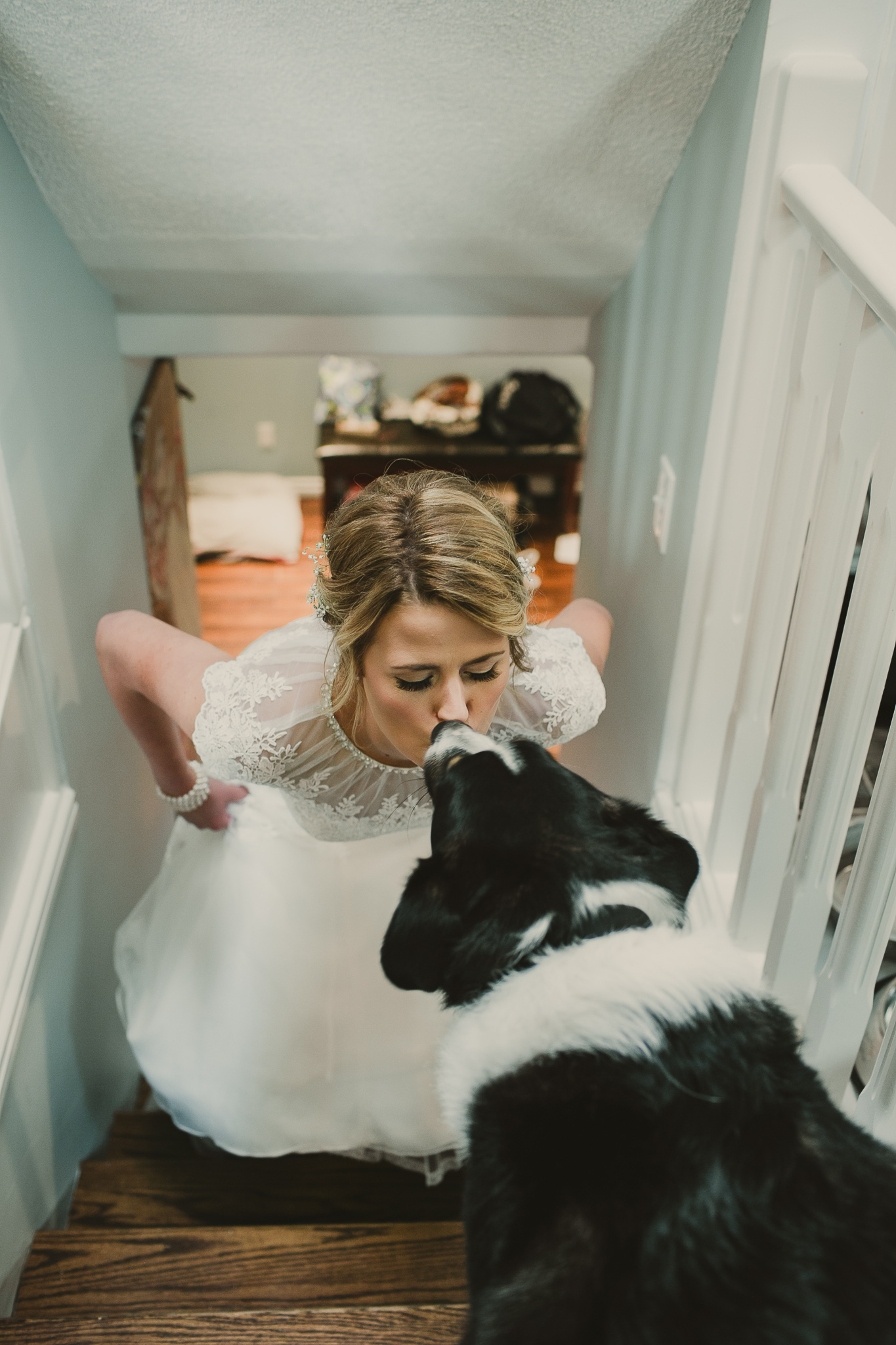 woman in a white dress kissing her dog