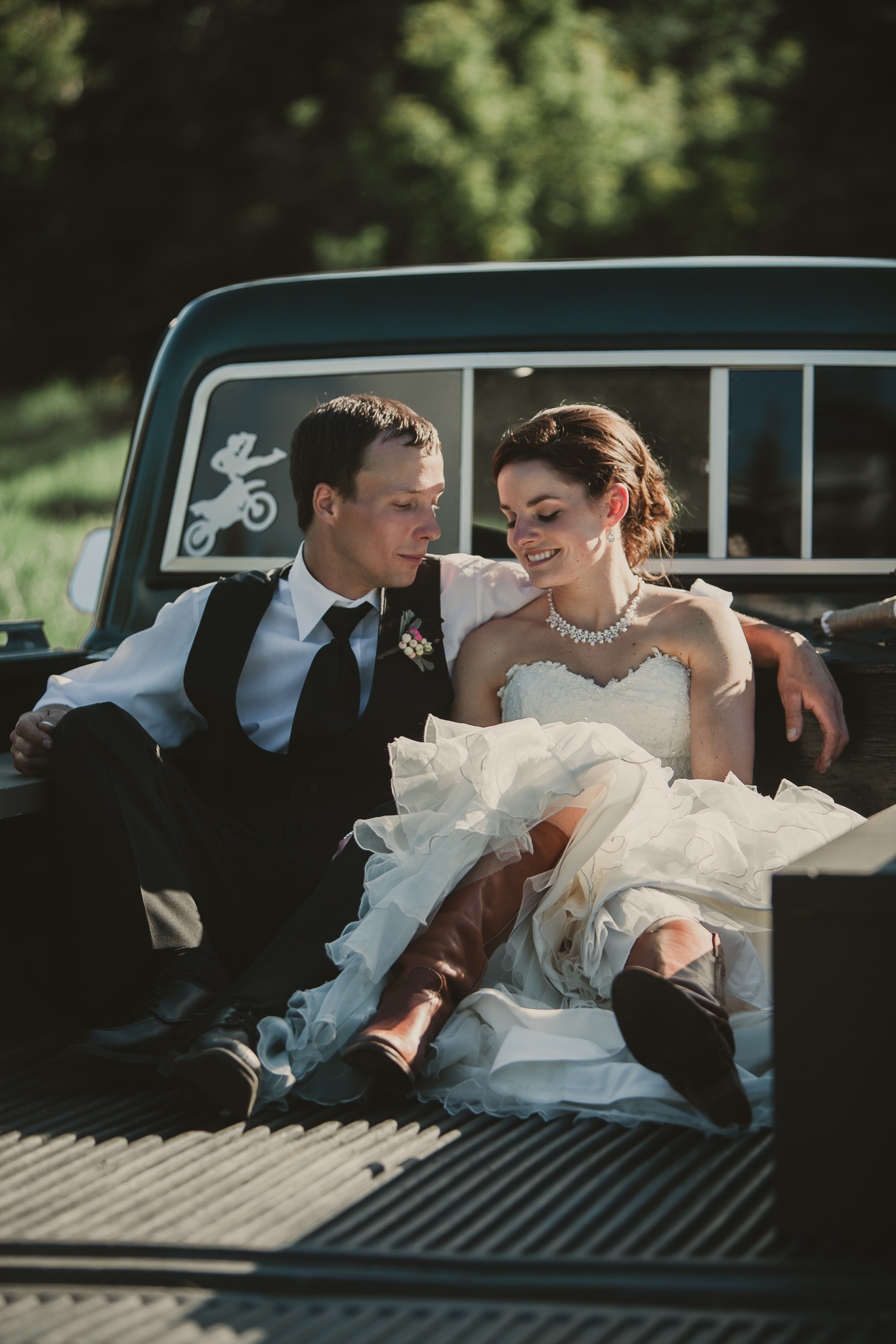 man and woman sitting the box of a pick up truck