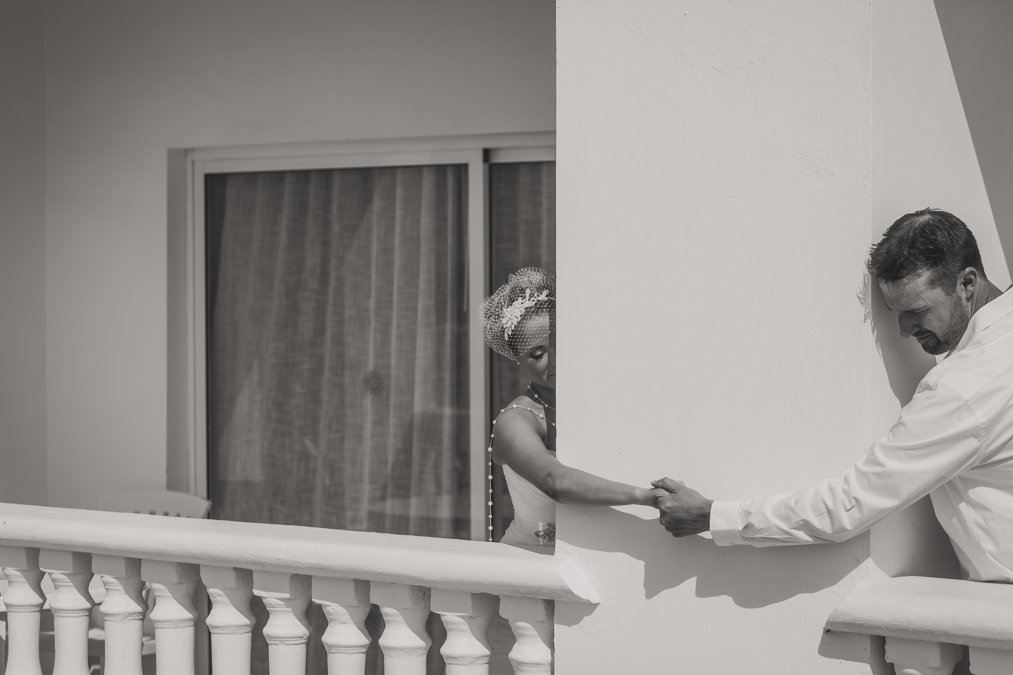 couple holding hands on a balcony