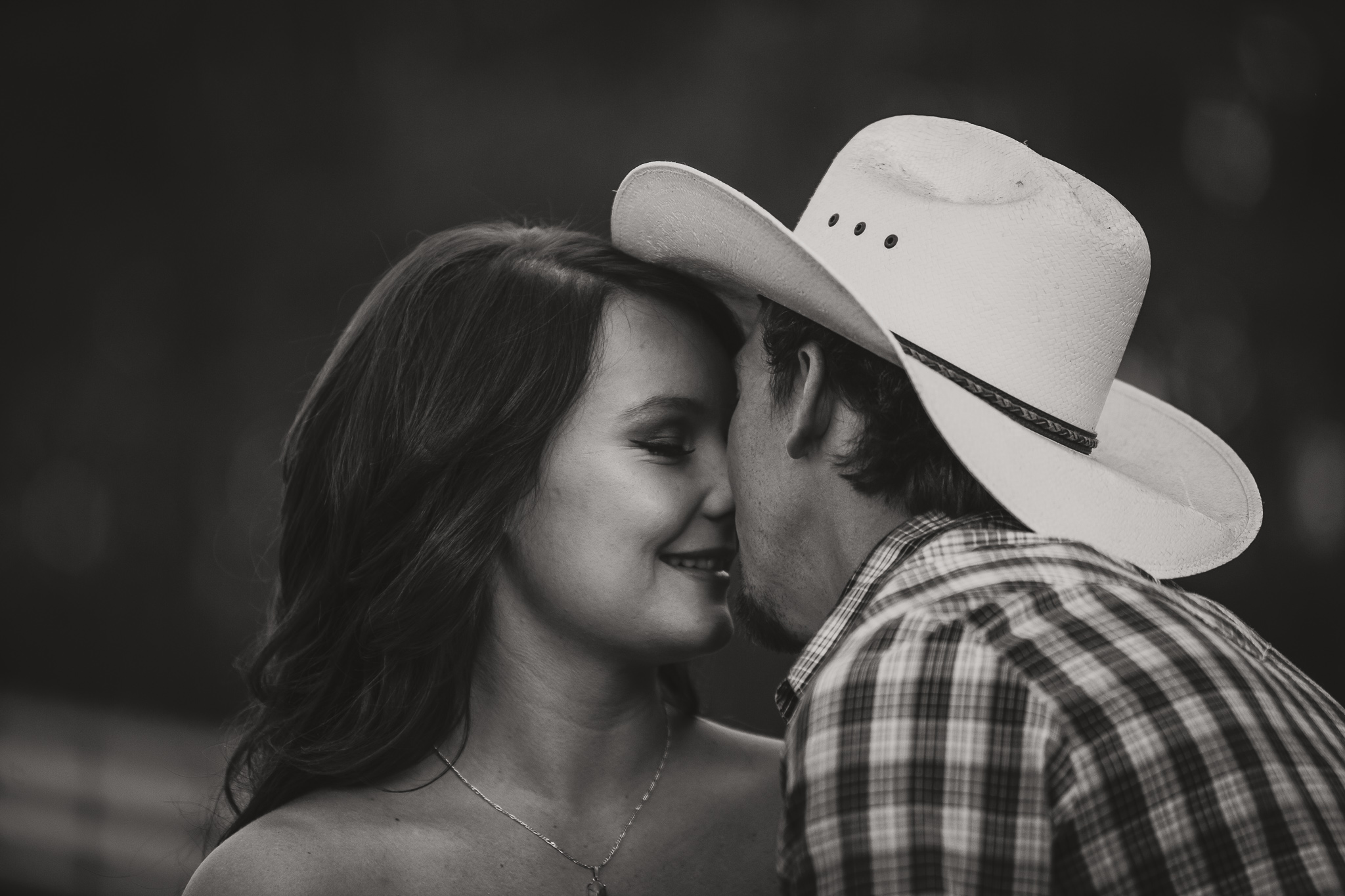 man in hat kisses woman black and white