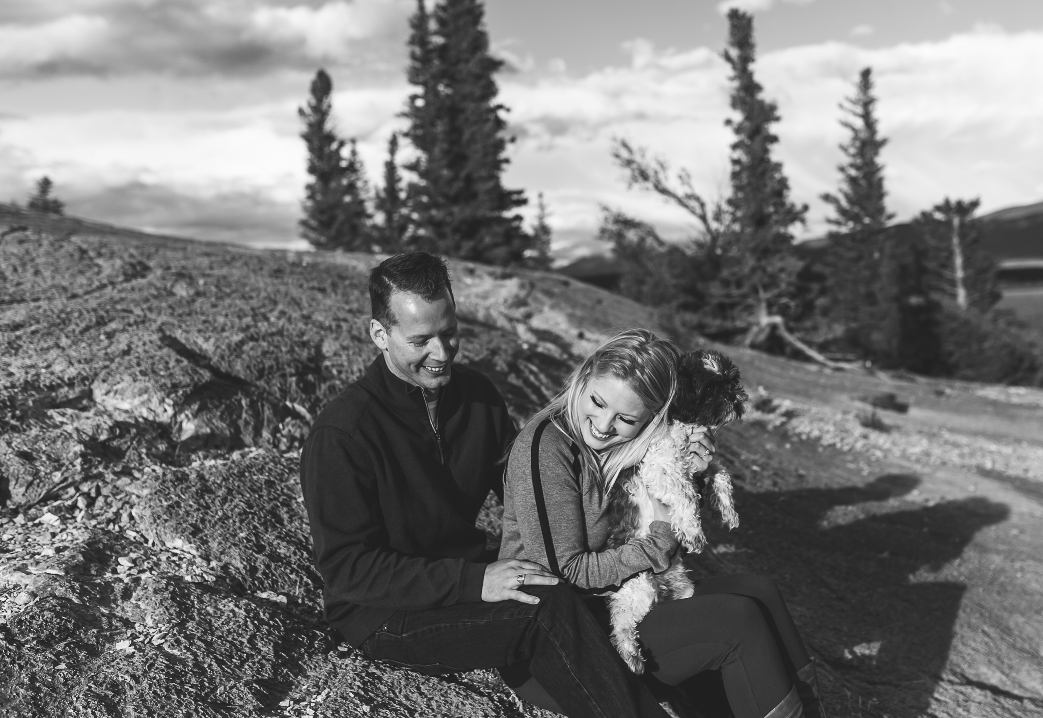 couple holding a dog in the mountains